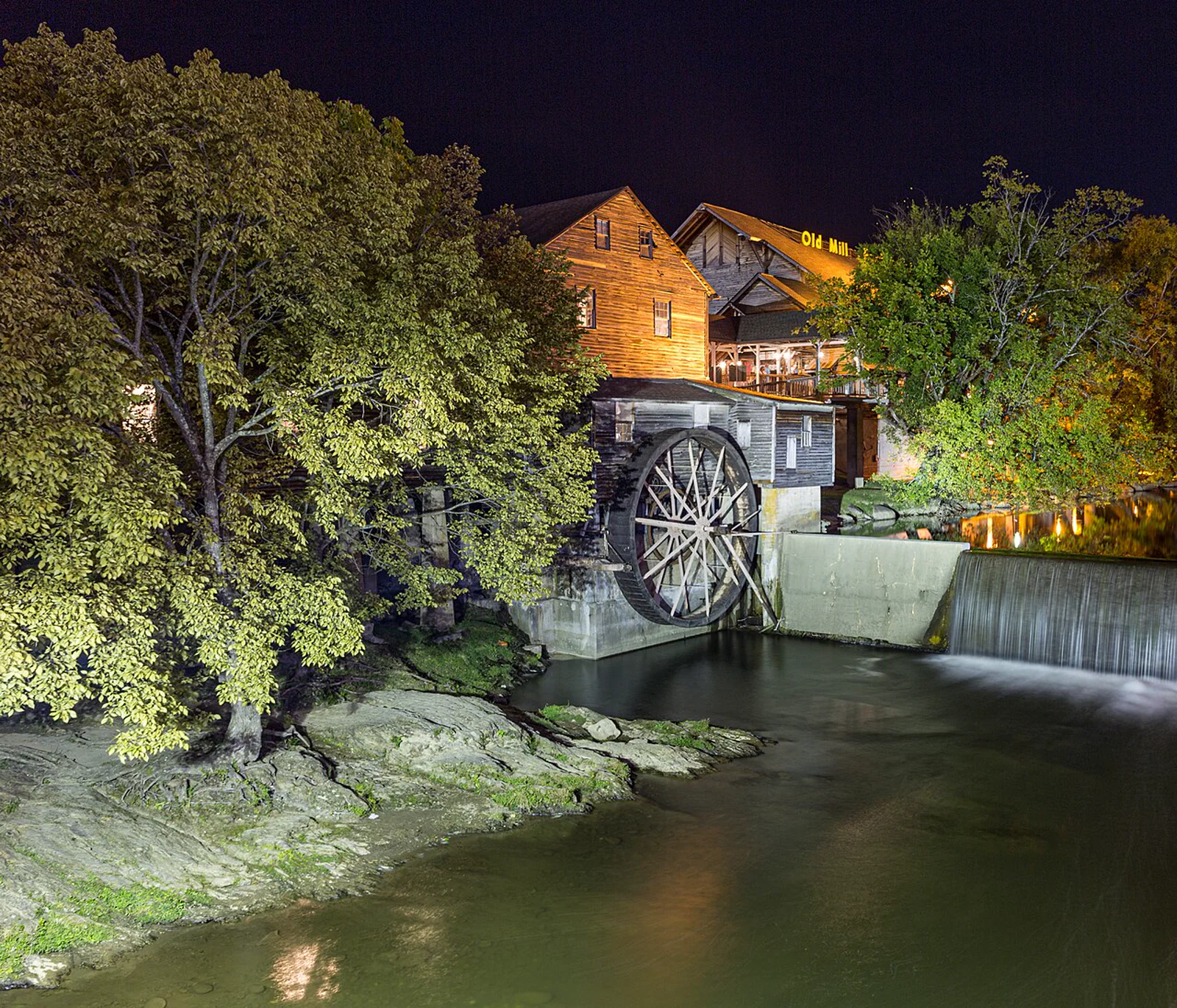 The Old Mill at night in Pigeon Forge, with the water wheel and dam