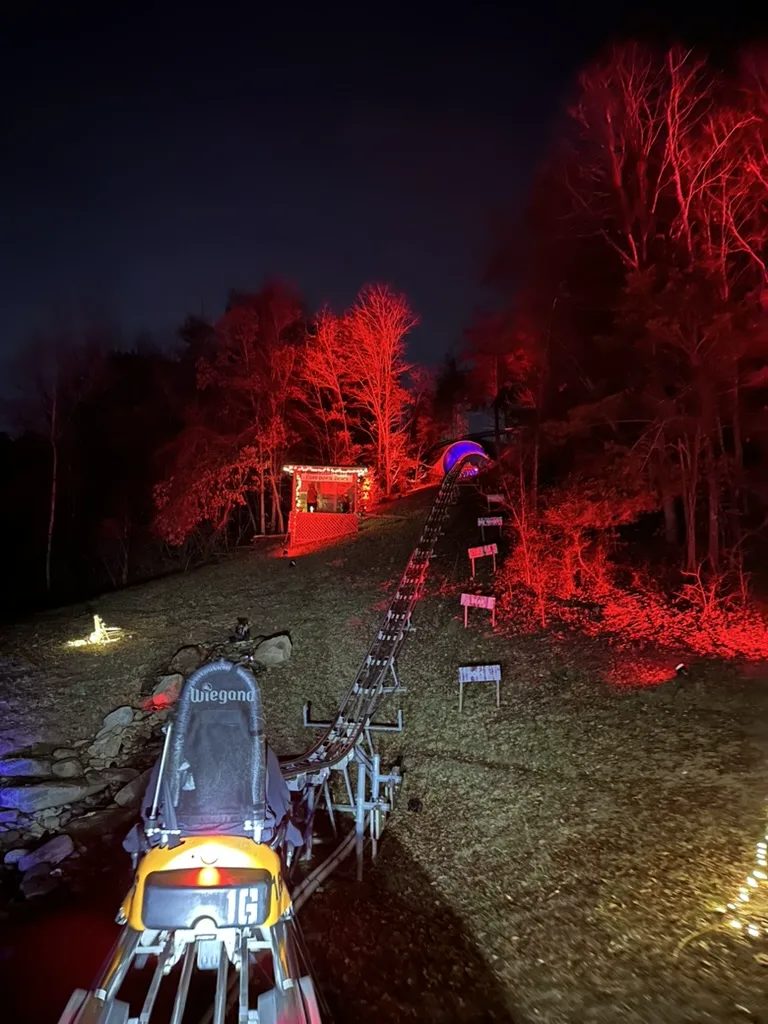 Night view from Rocky Top Mountain Coaster cart 16 climbing toward a lit tunnel