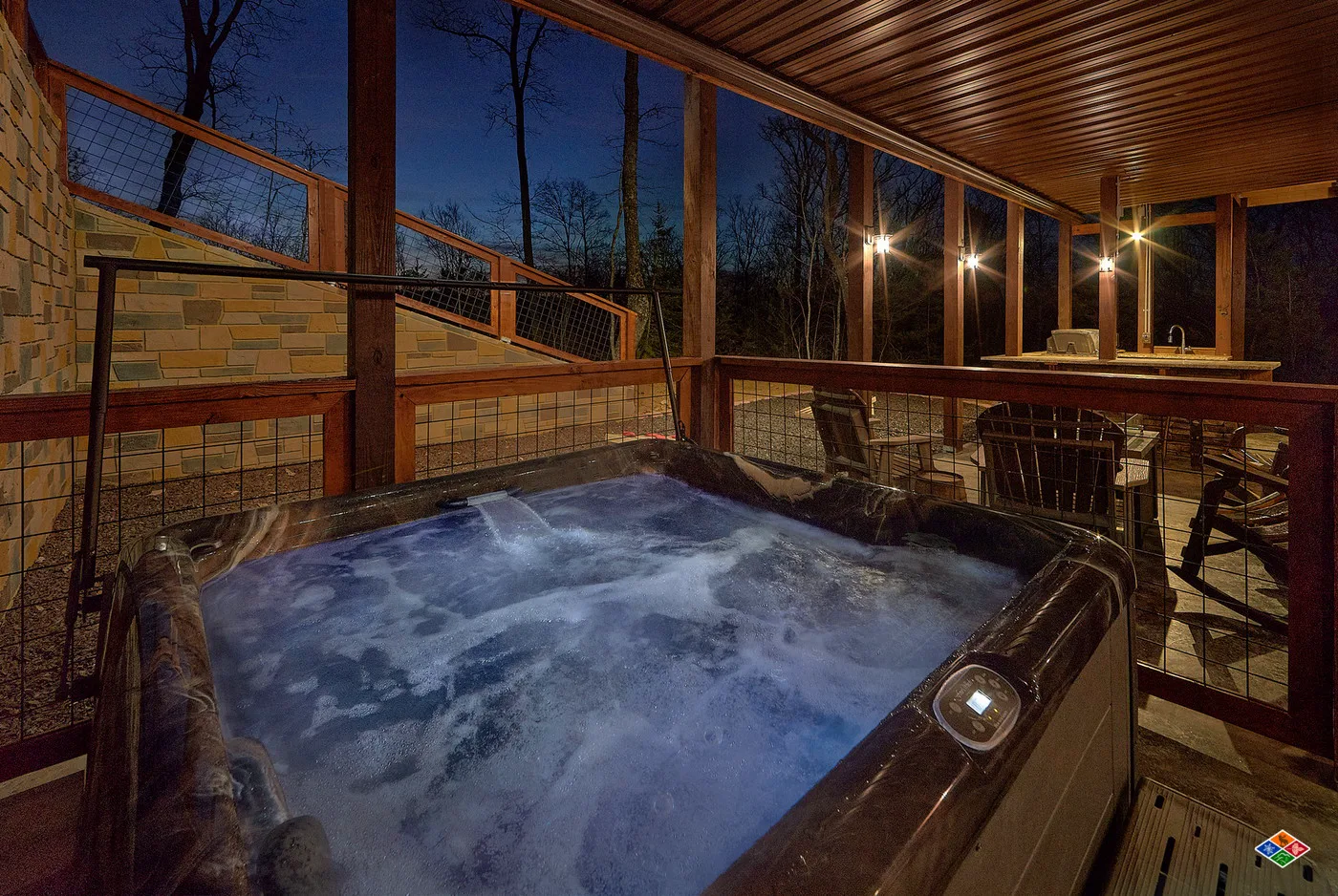 Covered outdoor hot tub at Barrel Top Lodge at night