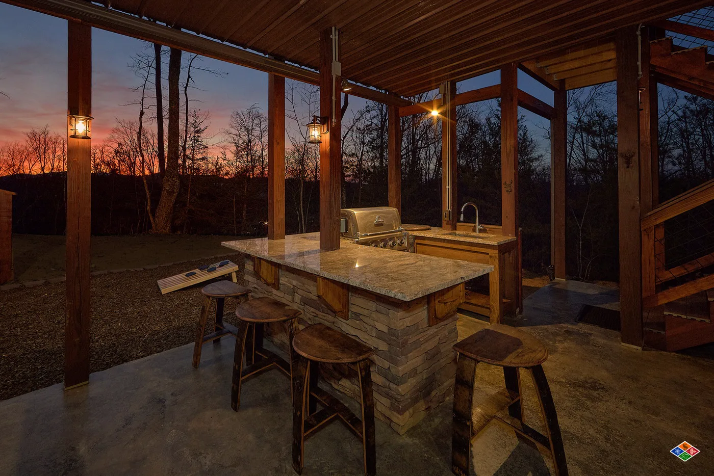 Covered outdoor kitchen at Barrel Top Lodge with a gas grill and bar seating