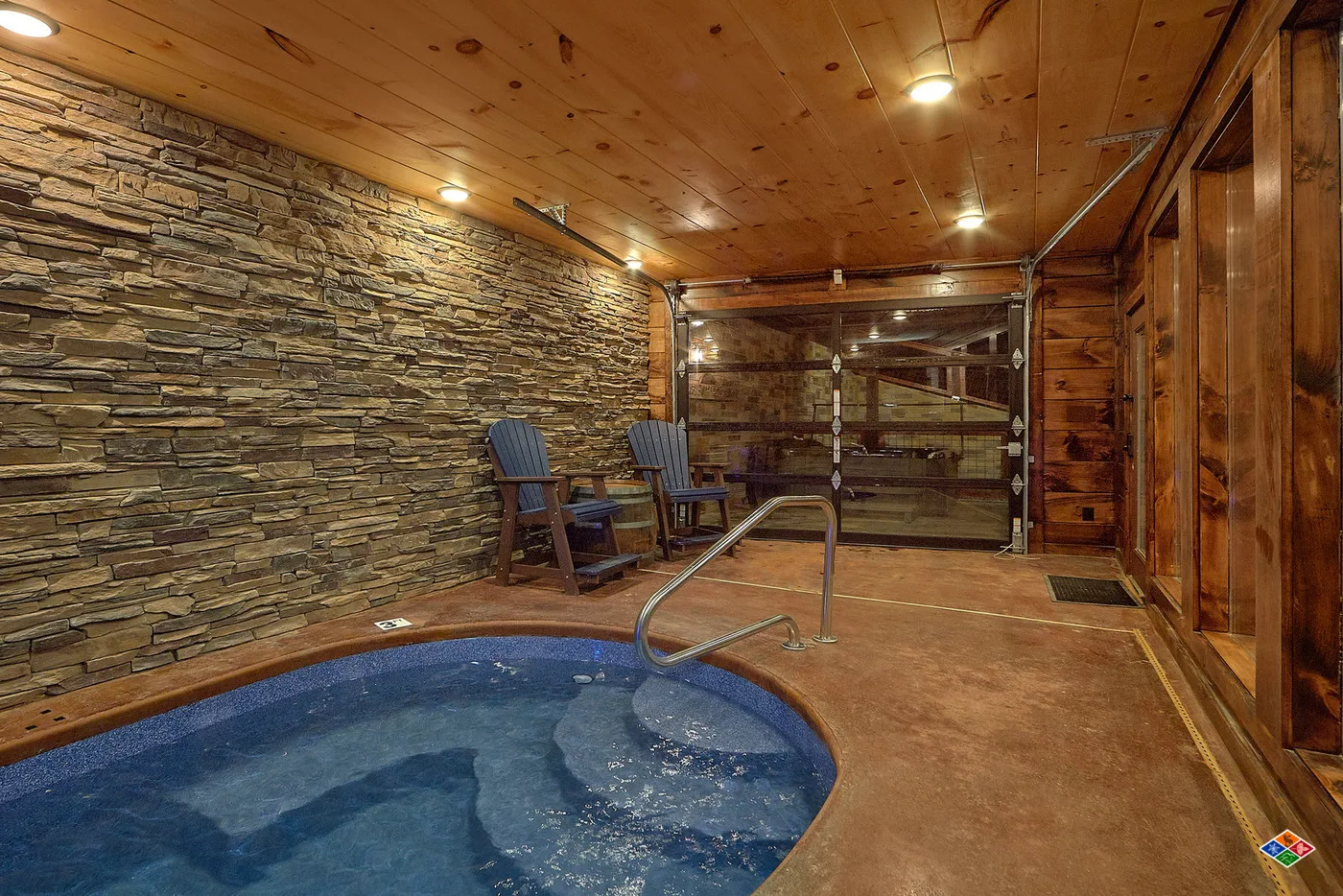 Indoor heated pool at Barrel Top Lodge with a stone wall and seating