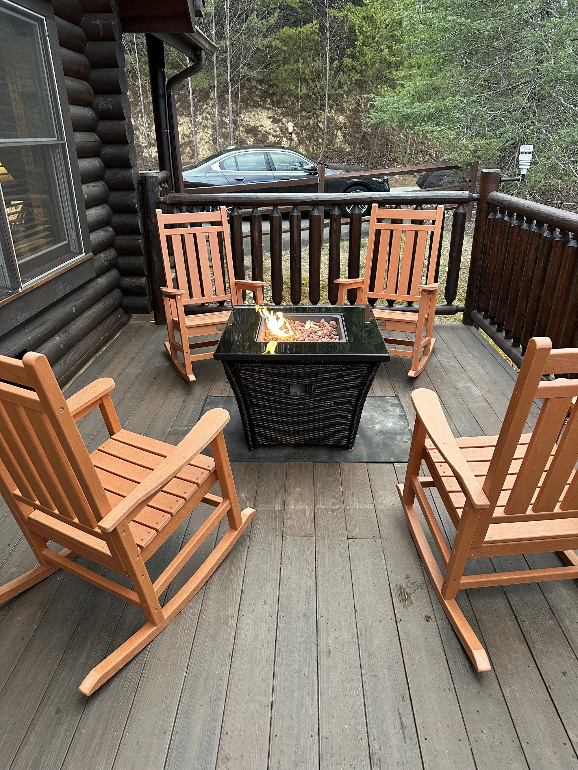 Fire table and rocking chairs on the covered deck at Cowboy Way
