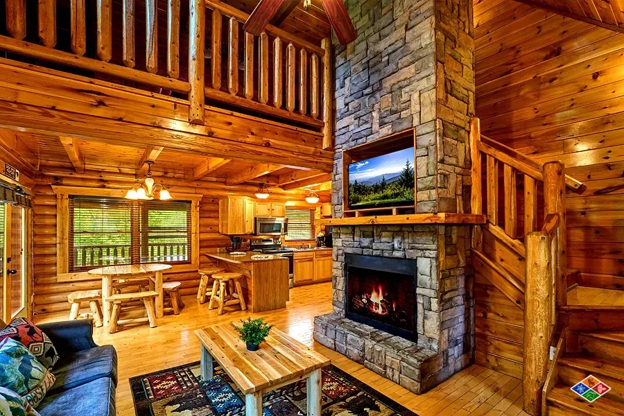 Cowboy Way great room with a floor-to-ceiling stone fireplace, loft, and open kitchen