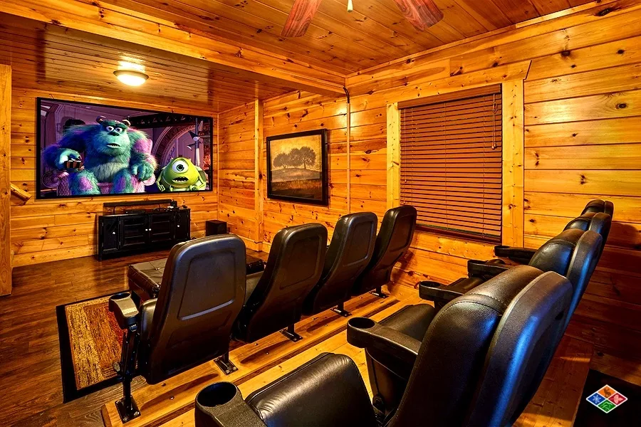 Home theater at Cowboy Way with tiered leather seats and a projection screen
