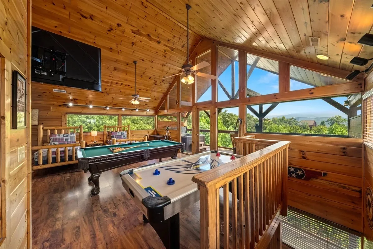 Game loft at Rocky Top Retreat with a pool table, air hockey, and mountain-view windows