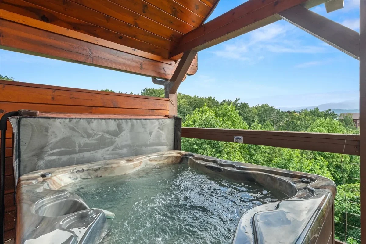 Outdoor hot tub on the covered deck at Rocky Top Retreat with a mountain view