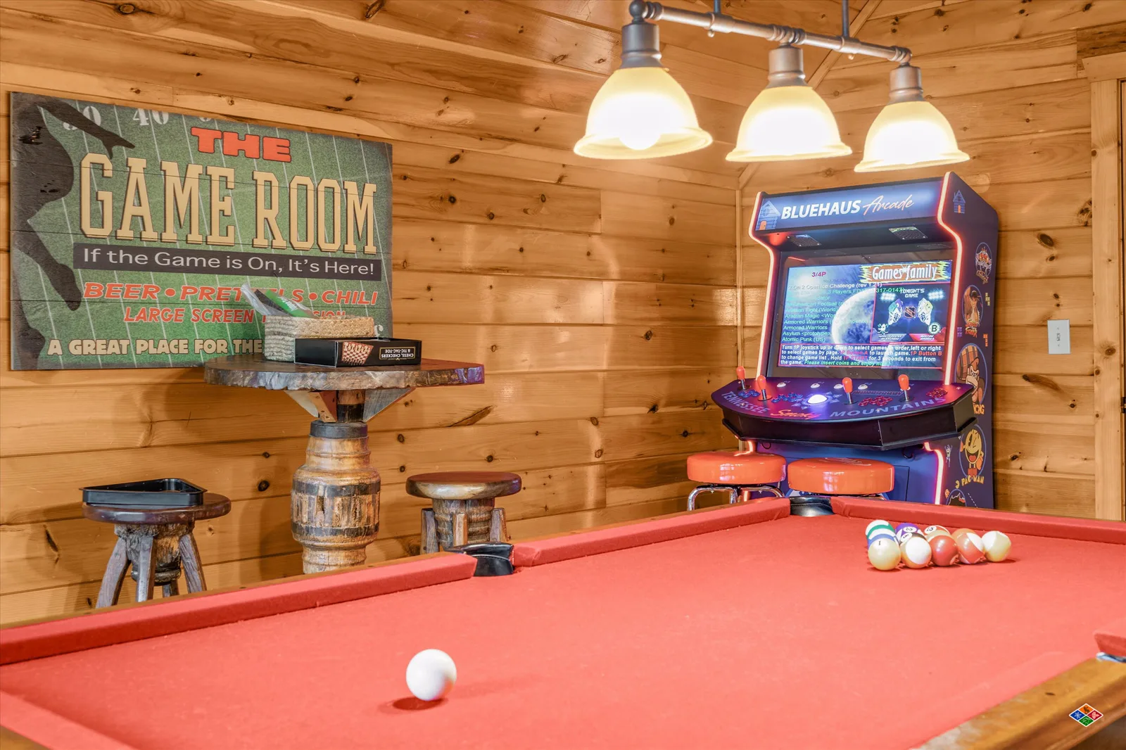 BLUEHAUS Arcade cabinet and red-felt pool table in the Summit Sanctuary game room